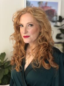 Red lips on a gorgeous woman with red hair. Makeup look by Rebecca Brown.